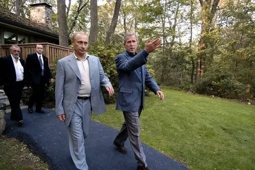 George W. Bush et Vladimir Poutine dans le parc de Camp David, le 26 septembre 2003 — la « diplomatie sans cravate ». Photo : White House / Eric Draper. Licence : domaine public. Source : White House Archives https://georgewbush-whitehouse.archives.gov/news/releases/2003/09/images/20030926-3_dsc2741putin-515h.html