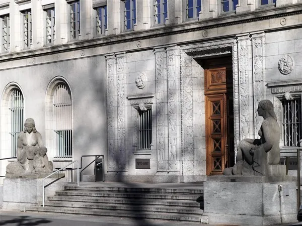 L’entrée principale du siège de l’OMC — le Centre William-Rappard à Genève ; les sculptures « Paix » et « Justice » (1925). Photo : Pierre-Yves Dhinaut / © OMC. Licence : CC BY-SA 3.0. Source : Wikimedia Commons https://commons.wikimedia.org/wiki/File:Cwr_main_entrance.jpg