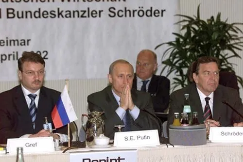 Guerman Gref (à gauche) — chef des négociateurs russes pour l’OMC — avec Vladimir Poutine et le chancelier Gerhard Schröder. Weimar, avril 2002. Photo : www.kremlin.ru. Licence : CC BY 4.0 (mention de www.kremlin.ru obligatoire). Source : Wikimedia Commons https://commons.wikimedia.org/wiki/File:Vladimir_Putin_in_Germany_9-10_April_2002-16.jpg